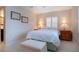 Cozy bedroom features terrazzo floors, furnishings, and lots of light from the shuttered windows at 1609 Bunker Hill Dr, Sun City Center, FL 33573