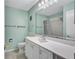 Bathroom featuring white vanity with a sink, commode, and a mirror reflecting the shower at 19029 Us Highway 19 N # 1-22, Clearwater, FL 33764