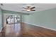 Bright living room boasting wood floors, a ceiling fan, and a sliding glass door to a balcony at 19029 Us Highway 19 N # 1-22, Clearwater, FL 33764