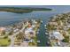 An aerial view shows this home with boat docks and access to the bay with surrounding community at 1936 Arrowhead Ne Dr, St Petersburg, FL 33703