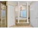 Luxury bathroom features a soaking tub with decorative tile surround, columns, and a shower stall at 19531 Deer Lake Rd, Lutz, FL 33548