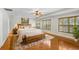 Stylishly staged bedroom boasting a large bed, hardwood floors, area rug and shuttered windows at 19531 Deer Lake Rd, Lutz, FL 33548