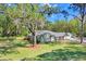 Charming single-story home with a lush green lawn, mature trees, and a long driveway at 19531 Deer Lake Rd, Lutz, FL 33548