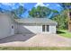 View of home exterior featuring an outdoor patio and white french doors in a well-manicured lawn at 19531 Deer Lake Rd, Lutz, FL 33548