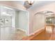 Hallway featuring hardwood and tile flooring, with doorways to adjacent rooms, showcasing the home's layout at 19531 Deer Lake Rd, Lutz, FL 33548