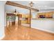Open-concept living space with wood floors, exposed beams, and a view of the kitchen with wood cabinetry at 19531 Deer Lake Rd, Lutz, FL 33548