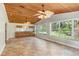 Bright, airy sunroom with a wood paneled ceiling, tile floors, a built in bar, and large windows overlooking the yard at 19531 Deer Lake Rd, Lutz, FL 33548