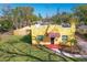 A high angle shows the front of the charming yellow home with new landscaping and fencing at 2310 13Th W Ave, Bradenton, FL 34205