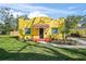 Charming yellow home with red tile entry, fresh landscaping, and a cozy front bench at 2310 13Th W Ave, Bradenton, FL 34205