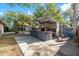 Backyard with a custom bar for outdoor entertaining, a shed for storage, and mature trees at 2412 Giddens Ave, Seffner, FL 33584