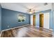 A blue bedroom with hardwood floors, a ceiling fan, and double closets at 2412 Giddens Ave, Seffner, FL 33584