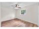 Comfortable bedroom featuring wood-look flooring, a ceiling fan, and a window with a peaceful view at 2412 Giddens Ave, Seffner, FL 33584