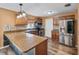 Renovated kitchen with stainless steel appliances, granite countertops, a tile backsplash, and a spacious center island at 2412 Giddens Ave, Seffner, FL 33584