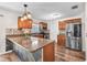 Well-lit kitchen showcasing a stylish island with granite countertops and stainless steel appliances at 2412 Giddens Ave, Seffner, FL 33584