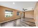 A spacious living room features a ceiling fan, two windows, and beautiful hardwood floors at 2412 Giddens Ave, Seffner, FL 33584