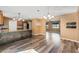 Open-concept living room and kitchen with wood floors and modern lighting fixtures, creating a warm and inviting atmosphere at 2412 Giddens Ave, Seffner, FL 33584
