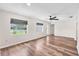 Bright, airy living room featuring wood-look floors, neutral paint, a ceiling fan and big windows with modern shades at 2412 Giddens Ave, Seffner, FL 33584