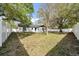 Well-maintained backyard featuring a white fence and mature trees offering shade and privacy at 2887 North Rd, Clearwater, FL 33760
