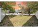 Charming home with a well-maintained lawn, mature trees, and a freshly painted white fence at 2887 North Rd, Clearwater, FL 33760