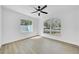 Bright bedroom featuring ceiling fan, wood floor, large windows, and neutral decor at 2887 North Rd, Clearwater, FL 33760