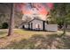 Charming single-story home featuring a freshly painted exterior, manicured lawn and white fence at 2887 North Rd, Clearwater, FL 33760