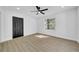 Bright living room featuring sleek ceiling fan, wood floor, large window, and neutral decor at 2887 North Rd, Clearwater, FL 33760