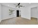 Bright living room featuring sleek ceiling fan, wood floor, large window, and neutral decor at 2887 North Rd, Clearwater, FL 33760