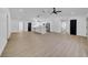 Spacious open-concept living area with luxury vinyl plank flooring, and a view of the bright, modern kitchen at 2887 North Rd, Clearwater, FL 33760