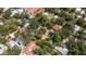An aerial view shows this home nestled within a vibrant neighborhood under a canopy of mature trees at 3026 51St S St, Gulfport, FL 33707