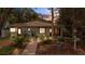Charming home at dusk with landscape lighting illuminating the walkway and lush front yard at 3026 51St S St, Gulfport, FL 33707