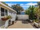 Charming exterior view featuring a white gated driveway, lovely plants, and a well-maintained garage at 3026 51St S St, Gulfport, FL 33707
