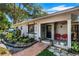 Charming home featuring a landscaped front yard and a welcoming covered porch with red chairs at 3026 51St S St, Gulfport, FL 33707