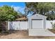 Exterior showcasing a detached garage with a newly installed concrete driveway and a white fence at 3026 51St S St, Gulfport, FL 33707