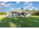 Backyard view of the home with a covered patio and a lush, green lawn at 3682 Johnstown St, North Port, FL 34288