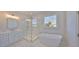 Modern bathroom featuring a soaking tub, tiled shower, and white cabinets at 3913 W Euclid Ave, Tampa, FL 33629