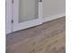 Close-up of gray hardwood flooring near a white door with glass panels at 3913 W Euclid Ave, Tampa, FL 33629