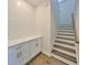 Hallway with staircase, modern white cabinets, quartz counters, and wood floors at 3913 W Euclid Ave, Tampa, FL 33629