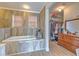 Spa-like bathroom with tiled soaking tub and walk-in closet with dresser at 4010 Jewfish Dr, Hernando Beach, FL 34607