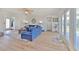 Bright living room featuring a blue sofa, hardwood floors and double glass doors to the deck at 4010 Jewfish Dr, Hernando Beach, FL 34607