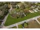 This aerial view showcases the expansive property with mature trees and multiple structures surrounded by roads at 4100 Ernest Dr, Wesley Chapel, FL 33543