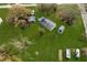 Aerial view of the property featuring a large yard with mature trees, outbuildings, and a charming fire pit at 4100 Ernest Dr, Wesley Chapel, FL 33543