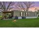 Spacious backyard with a covered patio, fire pit, and lush greenery, perfect for relaxation and outdoor gatherings at 4100 Ernest Dr, Wesley Chapel, FL 33543