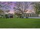 Expansive backyard with a home, shed, covered patio, and cozy fire pit, creating an ideal outdoor retreat at 4100 Ernest Dr, Wesley Chapel, FL 33543