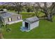 The property features an outbuilding with double doors and a concrete pad, surrounded by a well-maintained lawn at 4100 Ernest Dr, Wesley Chapel, FL 33543