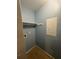 Laundry room featuring blue walls, tile flooring, and a storage shelf at 455 Alt 19 S # 217, Palm Harbor, FL 34683
