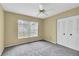 Well-lit bedroom features neutral walls and carpet with a window and closet at 7807 Hardwick Dr # 115, New Port Richey, FL 34653