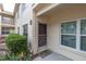 Exterior front entrance featuring welcome mat, plants, and large windows providing natural light at 7807 Hardwick Dr # 115, New Port Richey, FL 34653