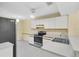 The kitchen features white cabinets, stainless steel appliances, a window, and tile floors at 7807 Hardwick Dr # 115, New Port Richey, FL 34653