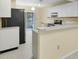 Contemporary kitchen with white cabinets, black appliances, and views of the screened patio at 7807 Hardwick Dr # 115, New Port Richey, FL 34653
