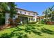 Expansive backyard featuring lush green lawn, mature trees, and charming screened-in porch at 808 Idlewood Ave, Tampa, FL 33609